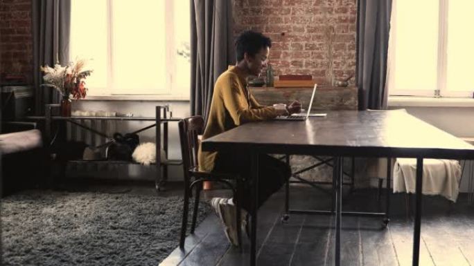 黑人女少年坐在桌子上在线笔记本电脑上工作