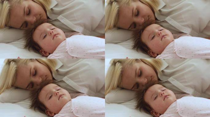 轻松平静的昏昏欲睡的妈妈和婴儿躺在白色床单上
