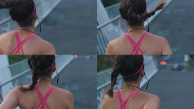 适合女性在户外城市的桥上从后面跑步和慢跑。一个年轻运动员在做有氧运动时用耳机听音乐的特写镜头。为了更