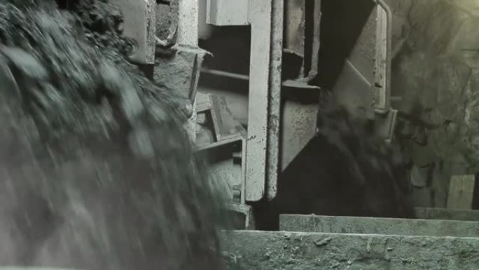重型机械和煤岩落入地下煤矿内部岩石表面的桶中。特写。