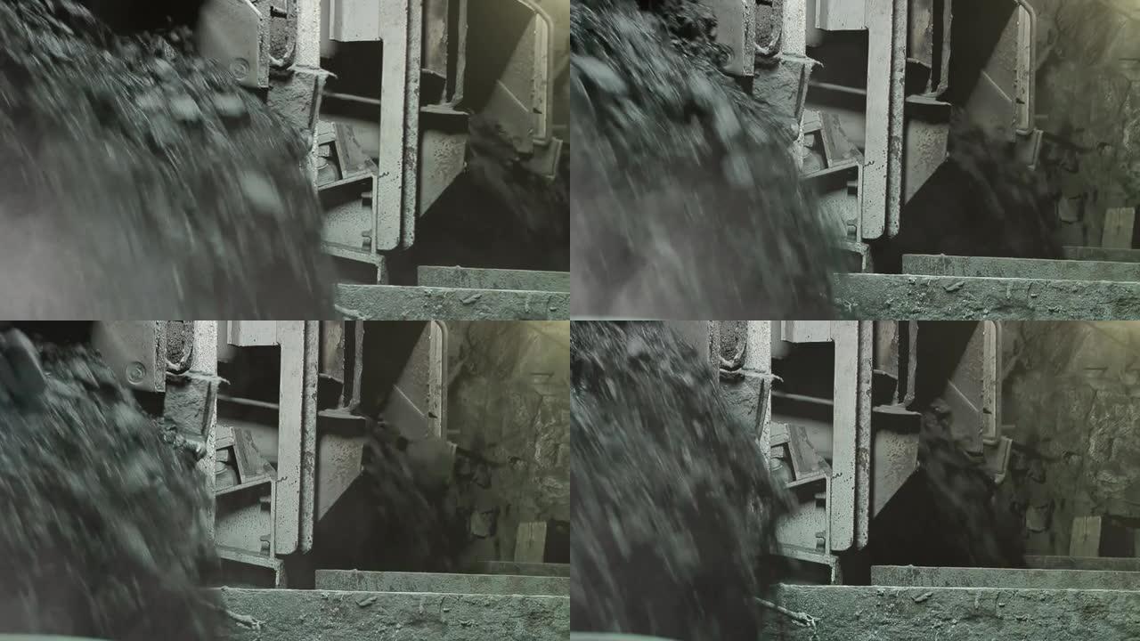 重型机械和煤岩落入地下煤矿内部岩石表面的桶中。特写。