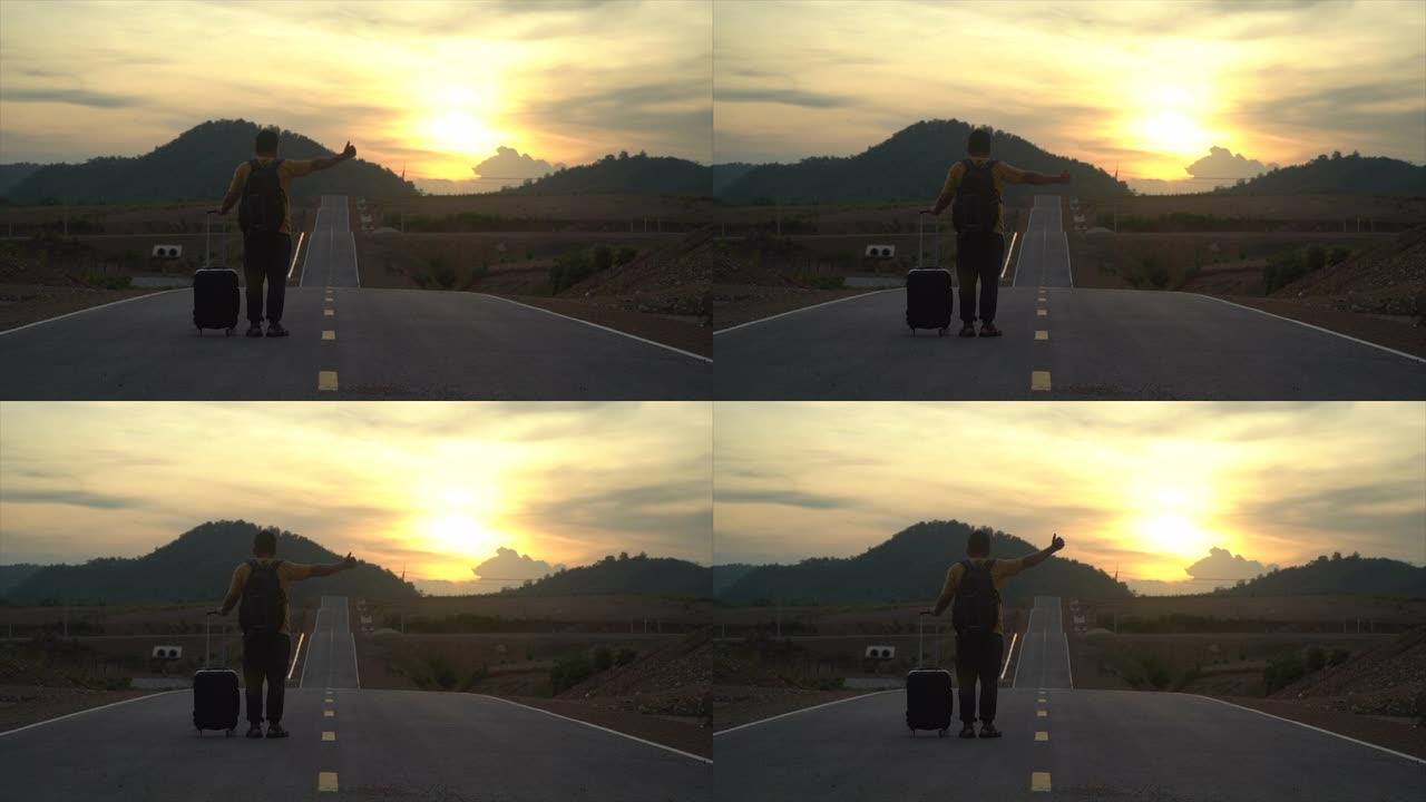 日落时分，一个男人在路上站着搭便车。