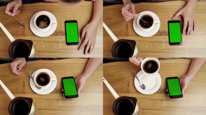 女士无法识别的人在家里喝咖啡时使用带有色度键绿屏的智能手机