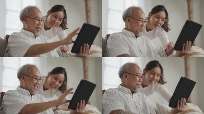 资深亚洲父亲和中年女儿在客厅的数字平板电脑上使用社交媒体