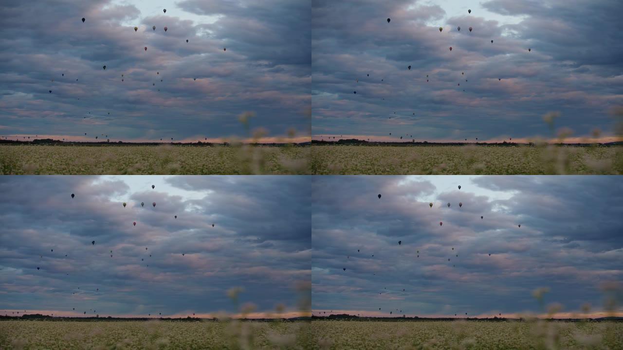 黎明时分，热气球在多云的天空中飞越乡村
