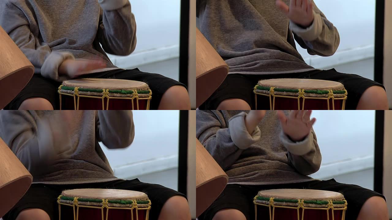 一个小男孩的手正在学习演奏康加鼓。特写。