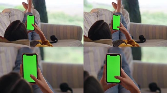 DS年轻女子在露台上的沙发上使用带色度键绿屏的智能手机