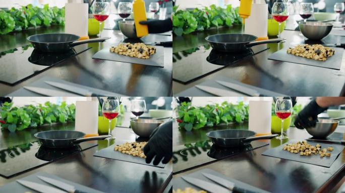 厨师手放在手套上的特写镜头使用现代电器在厨房的煎锅中煎炸食物
