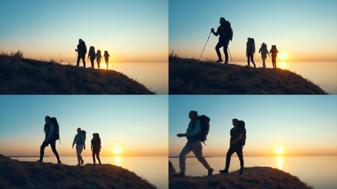 四位旅客走在靠海的山顶上。慢动作