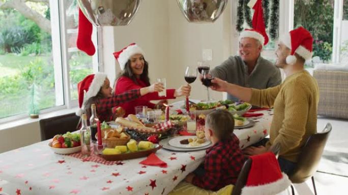 快乐的高加索多代家庭戴着圣诞老人的帽子，吃圣诞大餐，烤面包