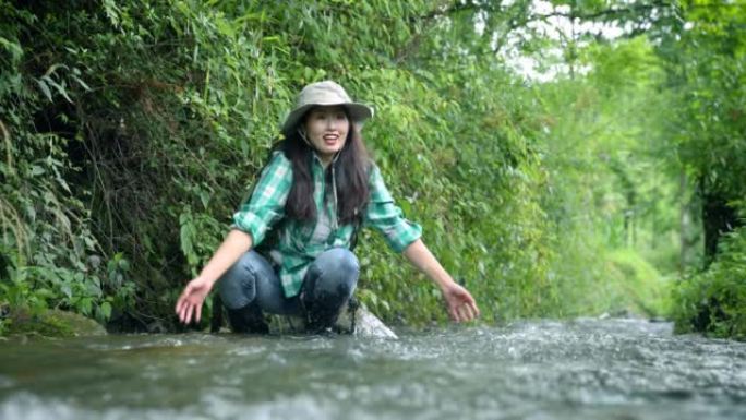 妇女在山间溪流中浇水