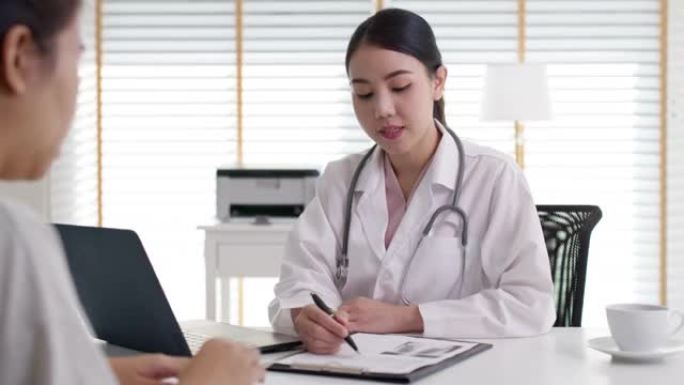 迷人美丽的年轻亚洲医生女性穿着白色礼服听诊器在肩膀上诊断与生病的病人交谈提供帮助，咨询在办公室诊所咨
