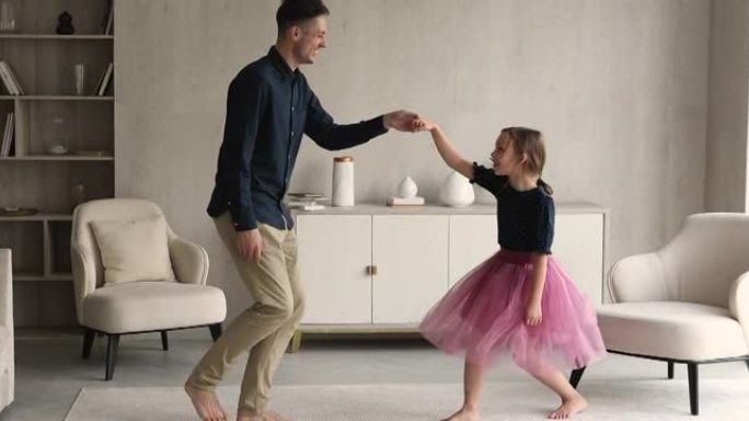 慈爱的爸爸和漂亮的女儿在客厅里跳舞