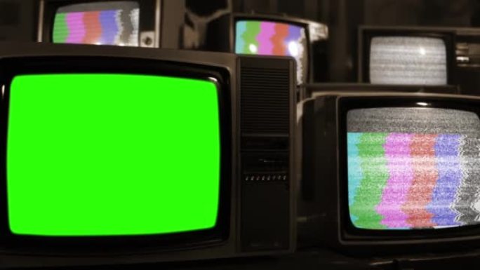 复古电视在许多具有静态噪声和测试图案信号的老式电视中打开色度键绿色屏幕。特写。棕褐色色调。