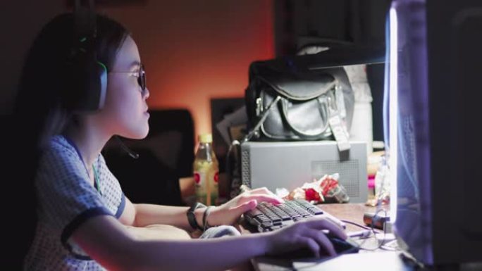 晚上在电脑上玩在线多人游戏的女孩玩家