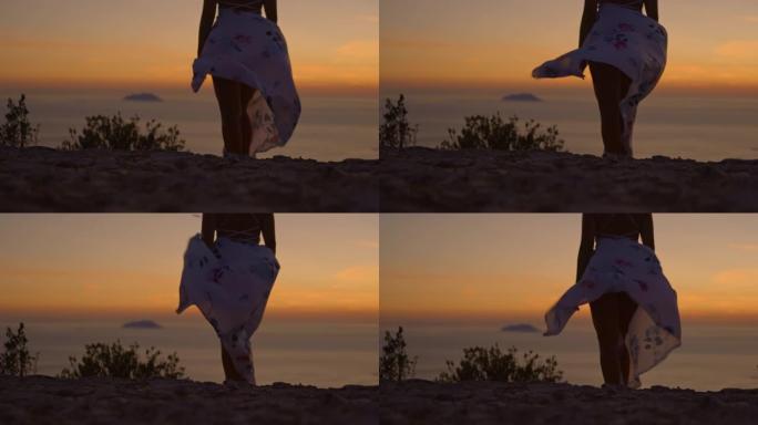 SLO MO在日落时，穿着白色连衣裙的女子欣赏迷人的海景