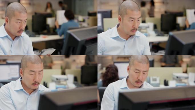 一个英俊的年轻商人坐在办公室并使用技术的4k视频片段