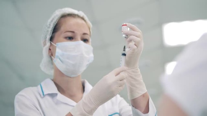 医务人员正在用冠状病毒疫苗填充注射器