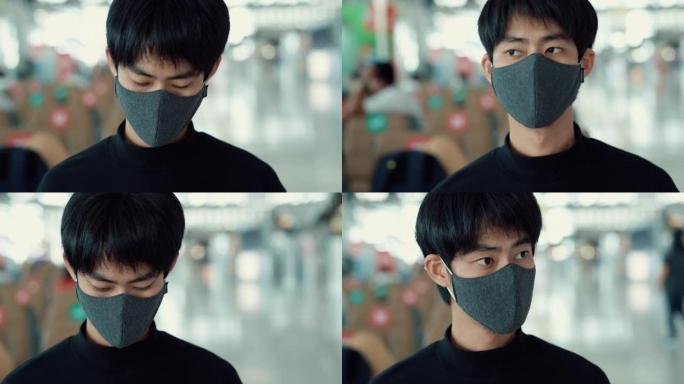 游客男子坐在机场时戴口罩保护