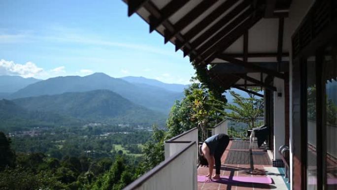亚洲中国中年妇女早上在乡村豪华山庄度假胜地度假期间练习瑜伽