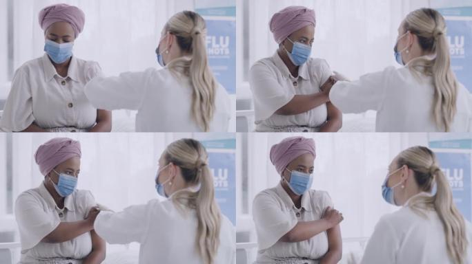 医生在医院给病人注射covid19疫苗。两名妇女戴着口罩，保护自己免受疾病传播。护士在接受枪击后与紧
