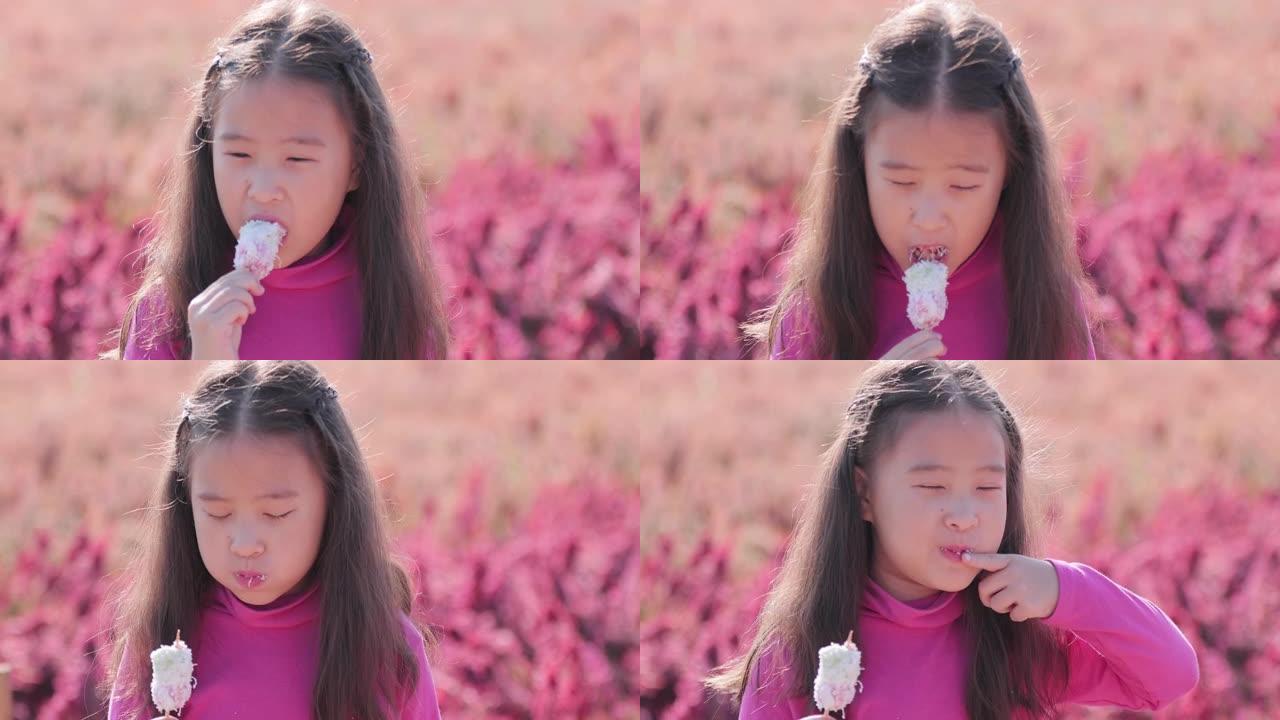 SLO MO美丽的小女孩在户外公园吃零食