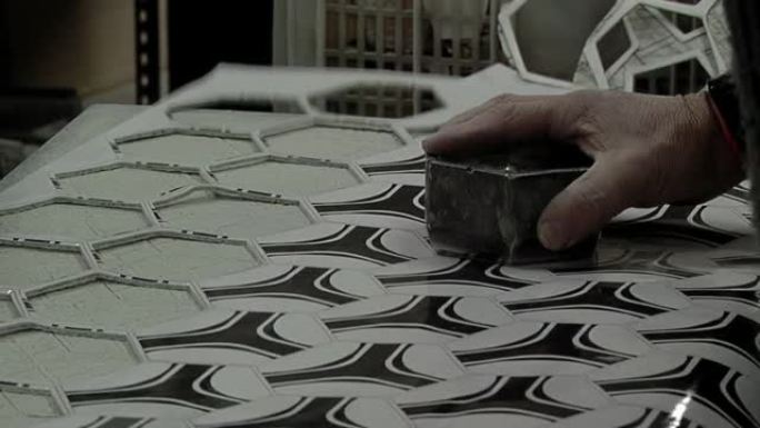 工人在一家足球工厂手工切割合成皮革六边形和五边形。特写。