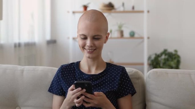快乐真诚的秃头女人使用智能手机应用程序。