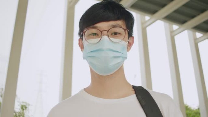 CU: 肖像亚洲男子微笑着戴着保护性口罩。