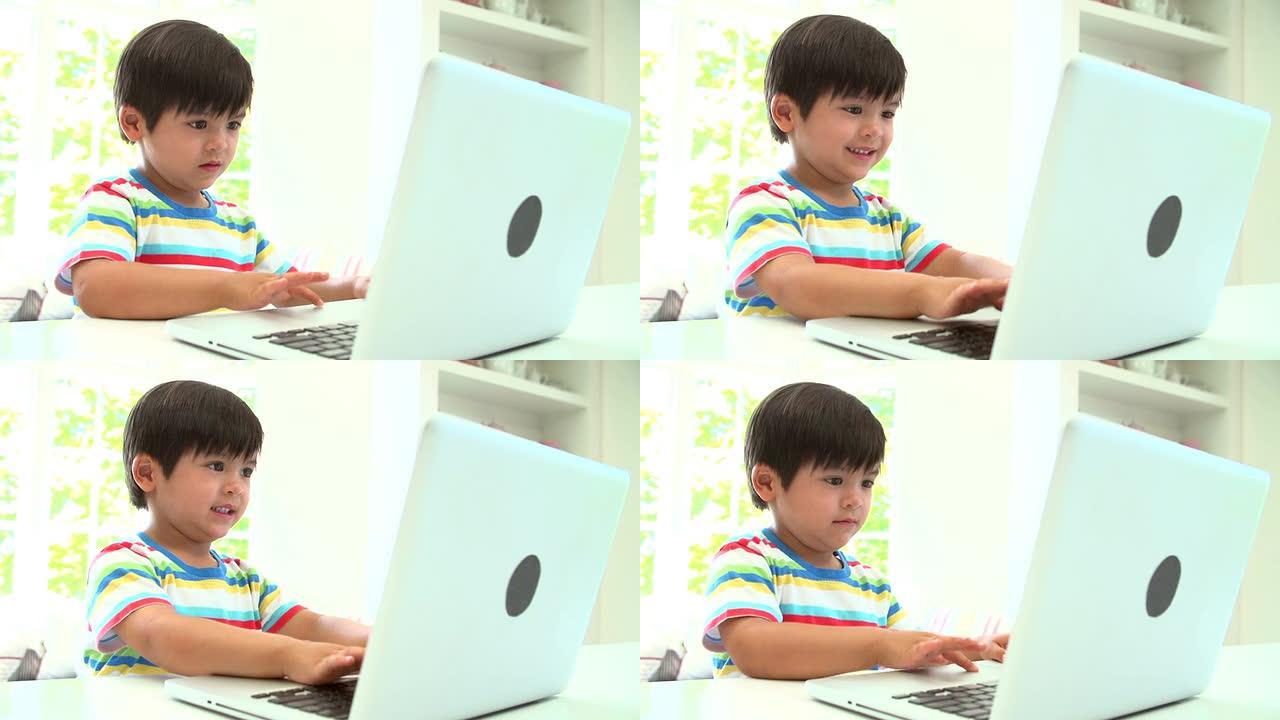 年轻的亚洲男孩在家里使用笔记本电脑