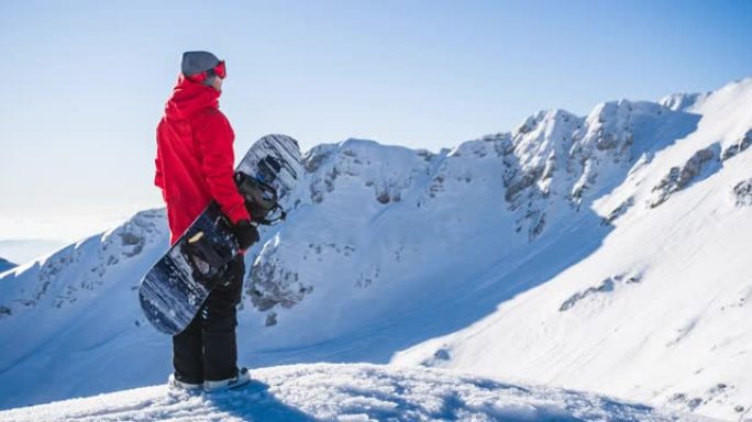 山顶上的滑雪者在阳光明媚的日子里欣赏冬季景观，并准备上坡