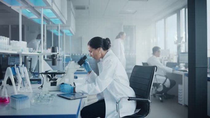 医学发展实验室: 美丽的高加索女科学家在显微镜下观察，分析培养皿样本的肖像。人们在高级实验室从事医学