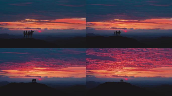 四位朋友站在山上，面对傍晚的云流