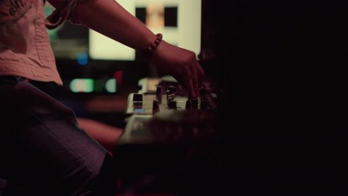 DJ在音乐会上在专业设备上混合音乐曲目。