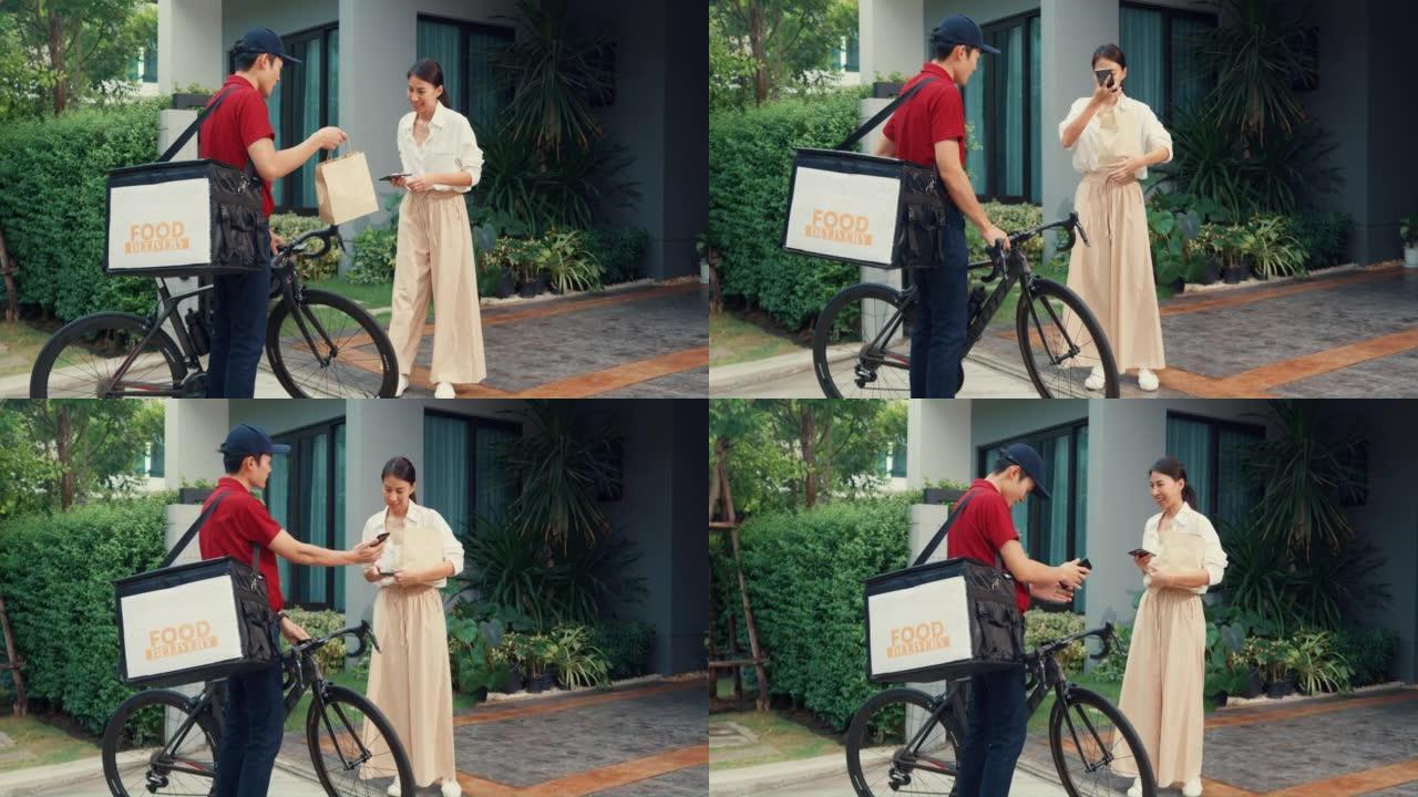 年轻的亚洲送货员，穿着红色制服的自行车，随身携带箱子敲门家庭网上购物纸袋给门前的女人，女士在家里用智