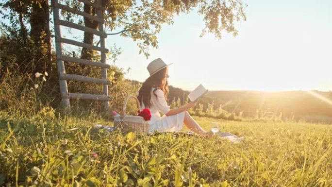 穿着白色连衣裙的慢动作年轻女子喜欢在大自然中读书