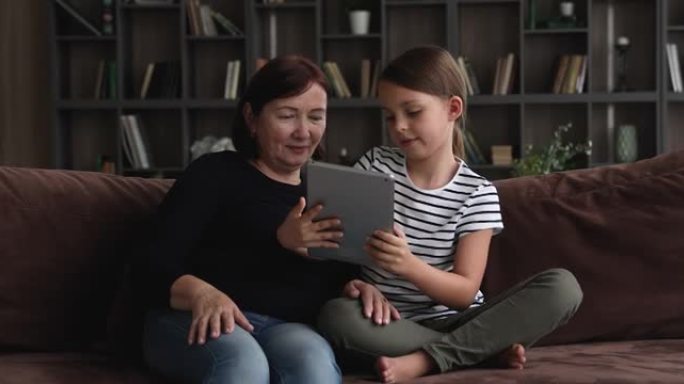 聪明的小女孩教老奶奶用平板电脑。