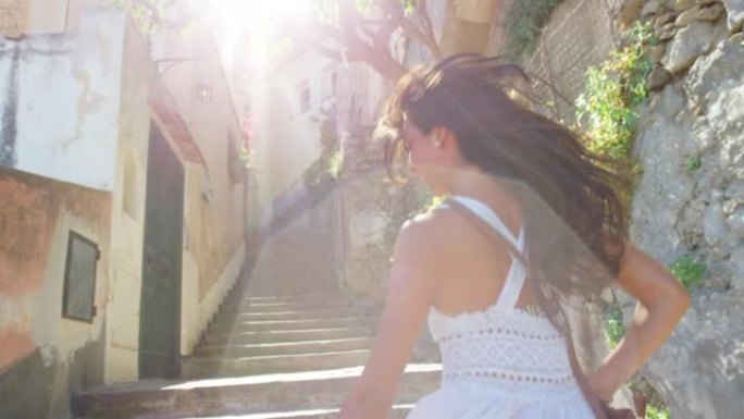 一个开朗的年轻女子在度假时跑上楼梯