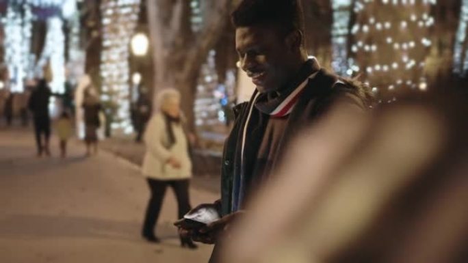 非裔美国男子在街上使用手机