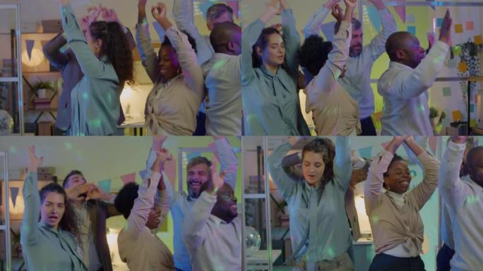 晚上，多元化的员工在工作场所跳舞，享受庆祝活动