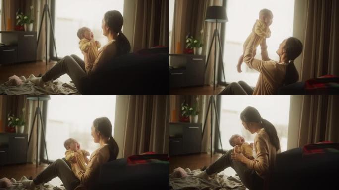 母亲和婴儿的亲密时刻: 一个刚成为母亲的亚洲妇女的真实镜头，早上在家与她可爱的孩子玩耍。母亲和婴儿的
