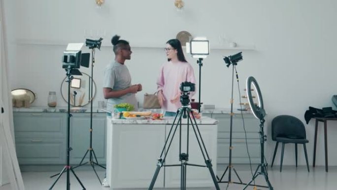 年轻的男人和女人在拍摄时谈论杂货。在线vlog概念，在线流媒体概念。