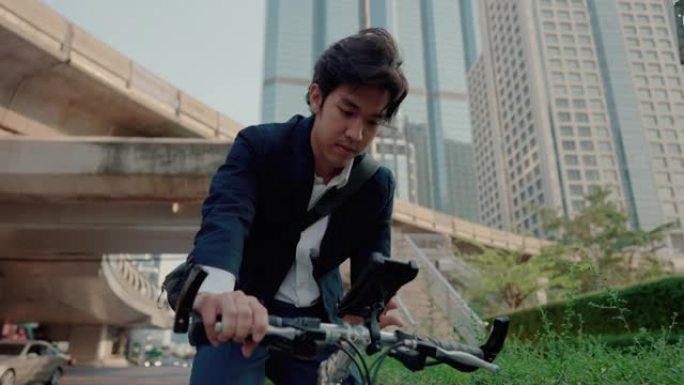 年轻的时髦男子在市中心的公园里骑自行车。