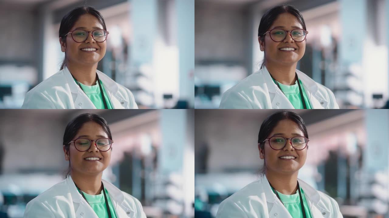 穿着实验室外套和眼镜微笑的年轻印度女专家的肖像特写。专业且成功的女性在大学实验室担任工程师，理科学生