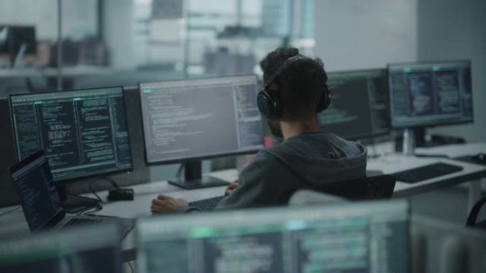 办公室: 专业的白色IT程序员在台式电脑上工作时使用耳机。男性网站开发者，软件工程师开发应用程序，视