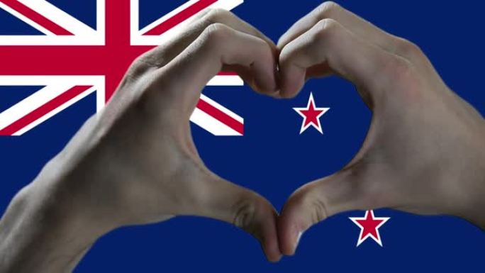 双手在新西兰国旗上显示心脏标志。