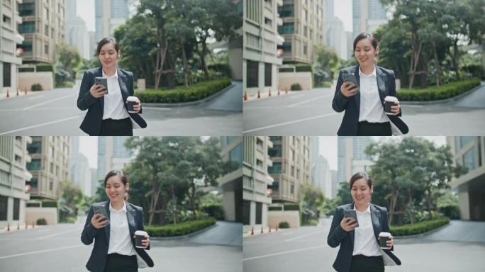 亚洲女商人一边用智能手机一边用咖啡杯走路