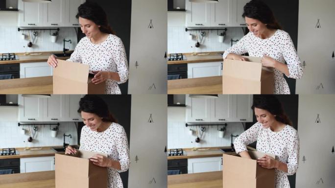 兴奋的年轻迷人的女人打开大纸箱。