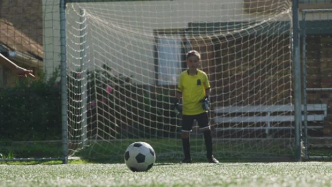 穿着蓝色衣服的非洲裔美国足球小子在阳光明媚的日子里进球
