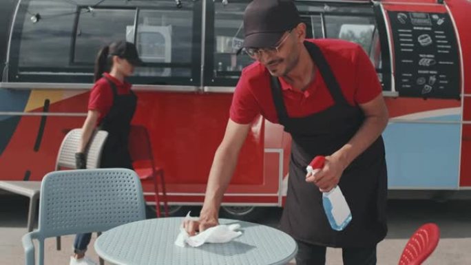 食品卡车工人在外面清洁桌子